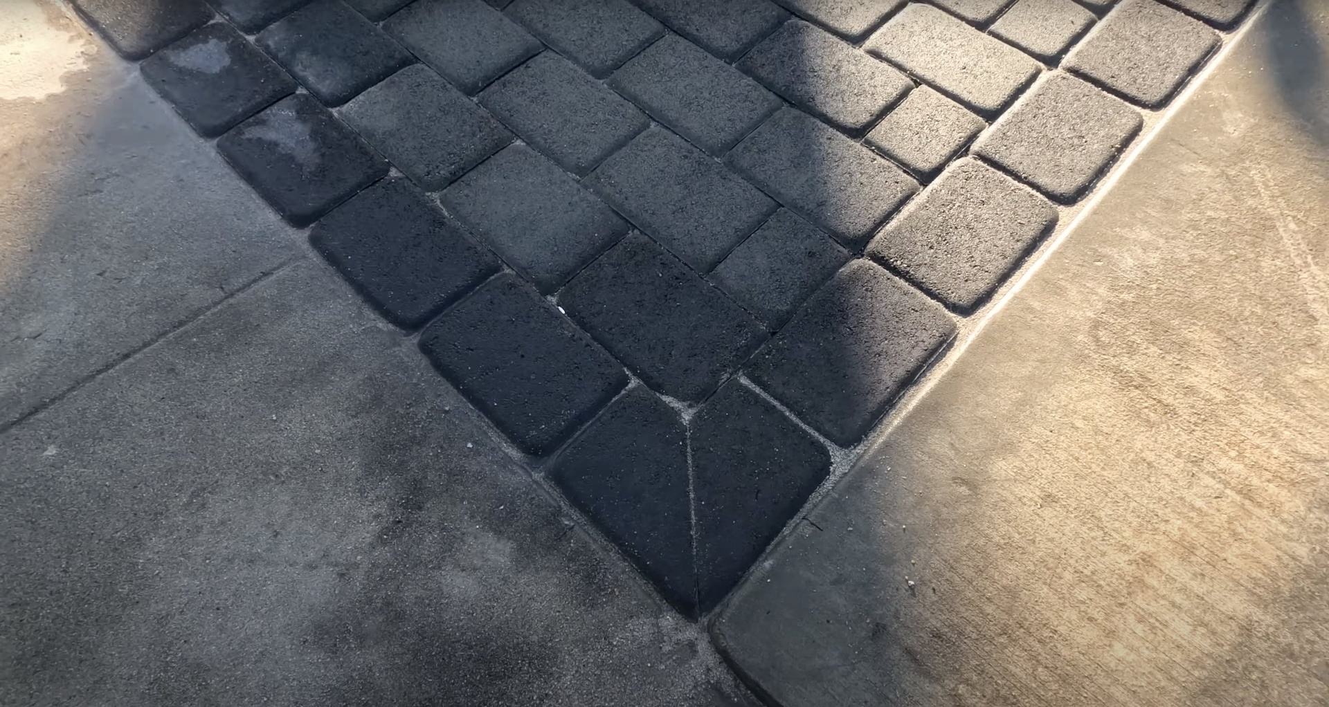 Interlocking concrete paver installation showing precision placement and pattern work
