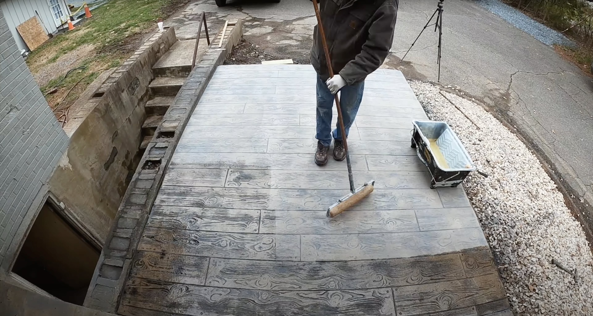 Stamped concrete patio with wood-grain pattern being finished by expert concrete contractor